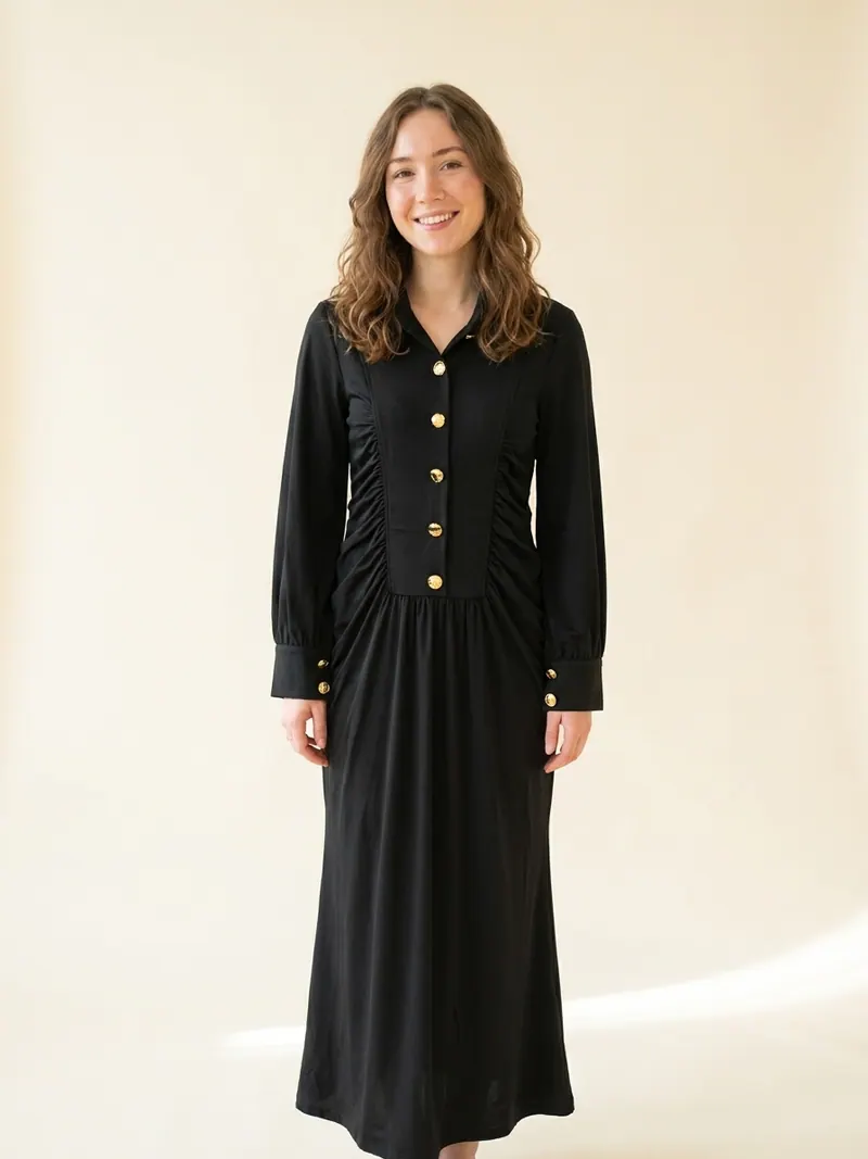 Modelo usando vestido negro con botones dorados de Franca Fortuna